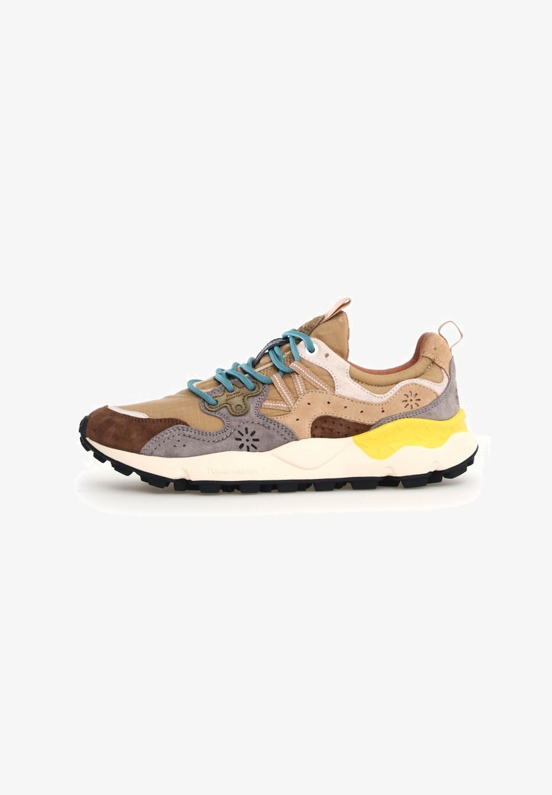 Beige und braune Wildleder- und Netzwerk-Sneaker mit türkisfarbenen Schnürsenkeln, weißen Akzenten und einer gelb-schwarzen Sohle. Mit strukturierten Mustern an den Seiten.