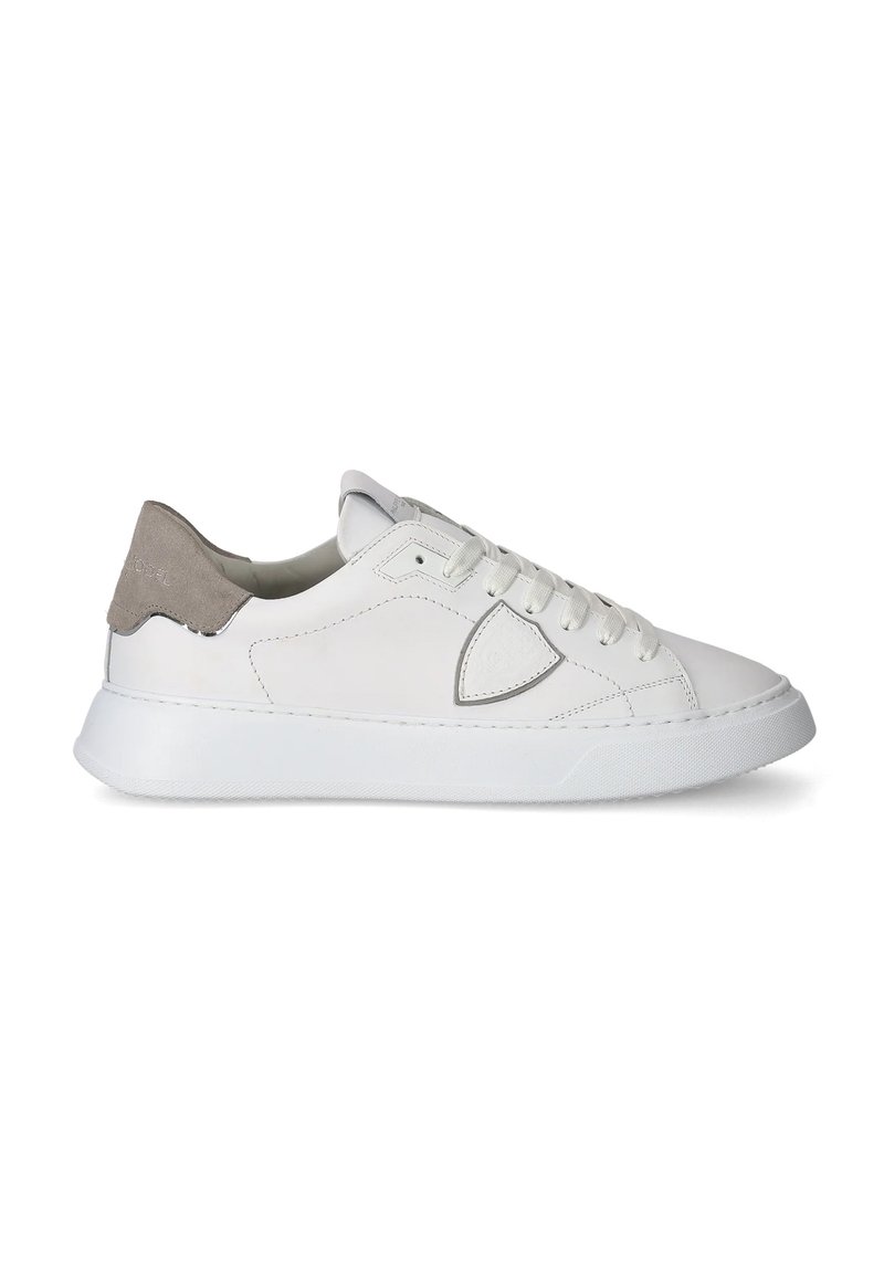 Białe skórzane sneakersy o zaokrąglonym kształcie, szary zamszowy tylny pasek, sznurowana zapięcie oraz teksturowana biała gumowa podeszwa. Minimalistyczny design.