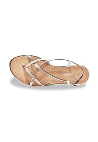 Sandalia plana con tiras, con plantilla de cuero beige, tiras metálicas plateadas y un acento blanco. Presenta una superficie suave y un diseño minimalista.
