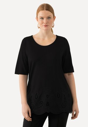 Sort kortærmet top med rund halsudskæring, prydet med detaljeret broderi langs kanten. Blødt, glat stof med en afslappet pasform.