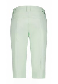 Pantaloni corti verde chiaro con una texture liscia, dotati di due tasche posteriori e un design sartoriale. La vita presenta un passante per cintura per regolazioni della vestibilità.