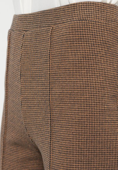 Hnedé a čierne nohavice s vzorom houndstooth, hladkou textúrou a ostrými skladmi pozdĺž prednej časti; priliehavý strih so bočnými vreckami.