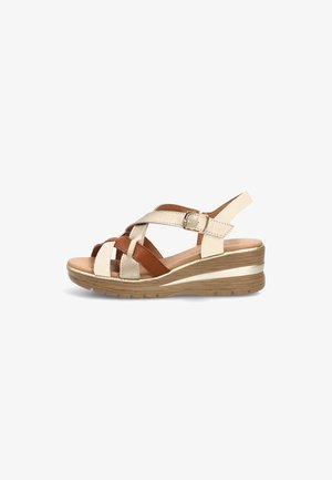 Sandalia de cuña de cuero beige y marrón con tiras cruzadas, hebilla ajustable y suela estriada con textura de madera.