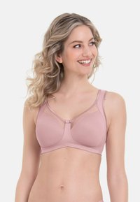 Lichtroze draadloze beha met gaasaccenten, zachte stof en een centrale sluiting. Brede banden en naadloze cups voor comfort en ondersteuning.