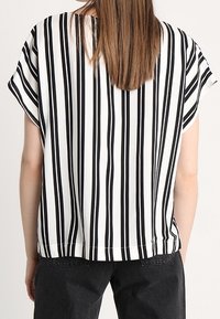Sort og hvidstribet bluse med korte ærmer, afslappet pasform, glat stof og rundet kant, set fra ryggen.