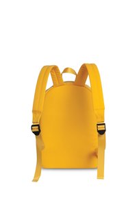 Sac à dos jaune avec des bretelles rembourrées et réglables et une forme arrondie. Texture lisse, design minimaliste, sans matériel visible.