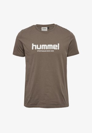 Brązowy bawełniany t-shirt z krótkimi rękawami, okrągłym dekoltem i dużym białym nadrukiem z napisem „hummel SPORTSWEAR SINCE 1923” na przedzie.