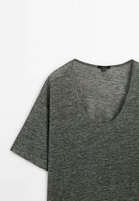 Szara koszulka z krótkim rękawem i dekoltem w serek. Wykonana z miękkiego, teksturowanego materiału z subtelnym melanżowym wzorem.