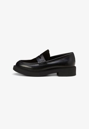 Black leather loafer with a smooth finish, featuring a suede accent on the upper and a chunky rubber sole. Minimalistic design with stitching details.