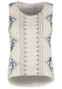 Blouse crème sans manches avec motifs géométriques de triangles bleus et noirs, encolure ronde et ourlet arrière légèrement plus long.