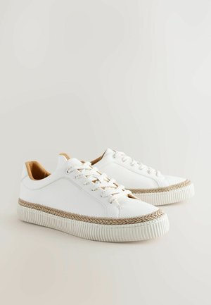 Baskets blanches avec un dessus en cuir texturé, une semelle intermédiaire tressée beige et des lacets ton sur ton. Semelle en caoutchouc plate avec des détails nervurés.