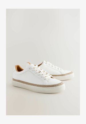 Adidași albi cu un superior din piele texturată, talpă intermediară împletită bej și șireturi tonale. Talpă plată din cauciuc cu detalii nervurate.