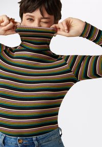 Mustassa ribbetti kaula-aukko ylhäältä alas suuntautuvilla vihreillä, vaaleanpunaisilla, keltaisilla ja sinisillä raidoilla. Ominaisuuksia ovat istuva malli ja pitkät hihat.