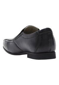 Chaussure en cuir noir avec une texture lisse, bout arrondi, petit talon et détails de couture contrastants. S'enfile facilement sans lacets.