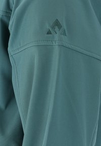 Lättvikts, turkos tygskjorta med en mjuk textur, subtil lyster och en broderad logotyp med triangelformer på axeln.
