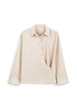 Beżowa koszula z długim rękawem z szpiczastym kołnierzykiem, asymetrycznym zapięciem na guziki zakrzywiającym się od klatki piersiowej do talii oraz szerokimi mankietami.