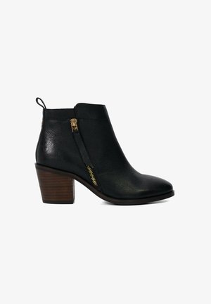 Schwarze Leder-Ankle-Boots mit strukturiertem Finish, goldenen Reißverschlussakzenten und einem klobigen Holzabsatz. Seitenreißverschluss für ein einfaches An- und Ausziehen.