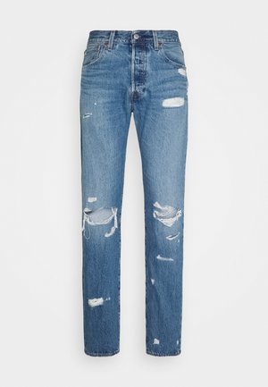 Jean en denim bleu avec une taille haute et plusieurs zones usées et déchirées à l'avant des jambes.