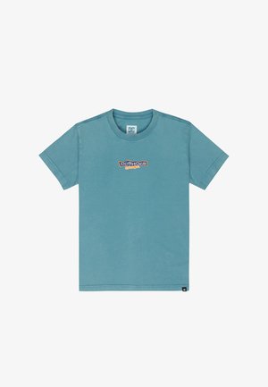 T-shirt en coton bleu clair à manches courtes avec logo, associé à un short en jean. Complété par des chaussettes blanches et des baskets noires/rouges.