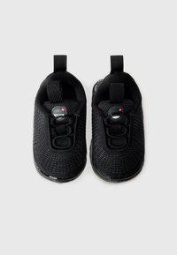 Baskets noires à enfiler avec un design tricoté texturé, des lacets élastiques, une languette au talon et une semelle en caoutchouc.