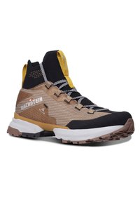 Baskets montantes d'extérieur en marron avec des accents noirs et jaunes. Elles présentent une tige en maille texturée, une semelle robuste et des lacets contrastants.