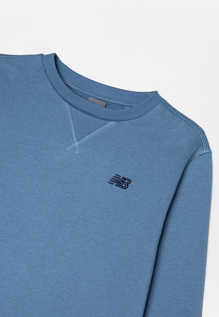 Blauwe pullover sweatshirt van zachte stof, met een geribde ronde hals, contrasterende stiksels en een klein donker logo op de borst.
