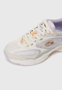 Balti ir levandų spalvos sportiniai bateliai su tinklinėmis detalėmis, bežinėmis virvutėmis, oranžinėmis akcentais ir siuvinėtą oranžinį krokodilo logotipą šone.