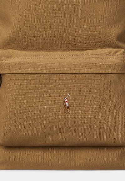 Καφέ υφασμάτινη τσέπη σακιδίου με μικρό κεντητό λογότυπο παίκτη πόλο πάνω σε άλογο που κρατά ανυψωμένο μαστίγιο.