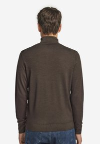 Brauner, langärmeliger Pullover mit hohem Kragen, geripptem Saum und strukturiertem Finish. Der Stoff sieht weich und figurbetont aus, mit schlichter Gestaltung.