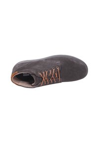 Zapato de ante gris con cordones marrones, punta redondeada y un cuello acolchado. Presenta una suela de goma plana y un detalle de costura mínima.