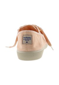 Sneaker in tela pesca chiaro con suola in gomma testurizzata, design con lacci e un'etichetta in tessuto cucita che mostra il logo del marchio sul retro.