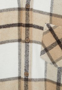 Beige, hvid og brun ternet uldstof med brune knapper og en syet klaplomme på højre side.