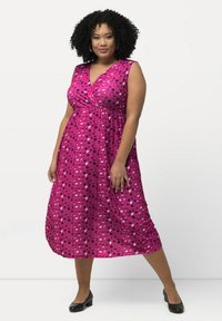 Fuksia ilmanhihaine mekko, jossa on kietaisusuunnittelu, monivärisiä pilkkuja pinkissä, valkoisessa ja sinisessä, sekä lennokas puolipitkä siluetti.