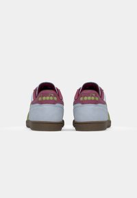 Colorful sneakers with a light blue suede upper, maroon accents, green detailing, and brown rubber soles. Branding visible on the heels.