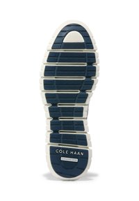 Modrá gumová podrážka s texturovaným gripem, bílá mezistélka a embossing "Cole Haan Grand 360". Vyznačuje se segmentovaným, sportovním designem pro flexibilitu.