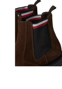 Stivaletti in suede marrone con pannelli elastici laterali in tessuto nero e strisce rosse e bianche, una texture liscia e suola in gomma.