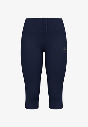 Marineblauwe stretchlegging met een gladde textuur, cropped lengte en platlock naden. Bevat een klein logo detail op de voorkant van de tailleband.