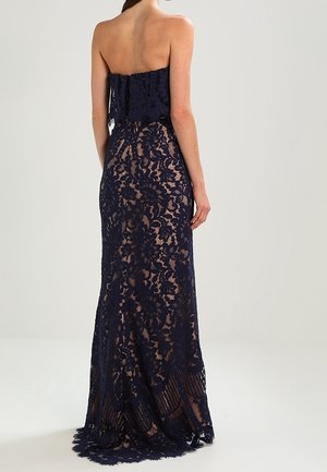 Granatowa sukienka bez ramiączek z koronki z misternymi kwiatowymi wzorami, dopasowanym gorsetem i sylwetką syreny, z falbankowym dołem i delikatną fakturą.