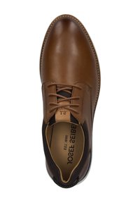 Bruine leren veterschoen met een ronde neus en contrasterend zwart elastisch zijpaneel. Beschikt over een gestikte zool en een textuur inzool.