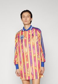 Long-sleeve jersey in vibrant pink, orange, and yellow with floral patterns. Features a blue collar and striped accents. Logo on chest.