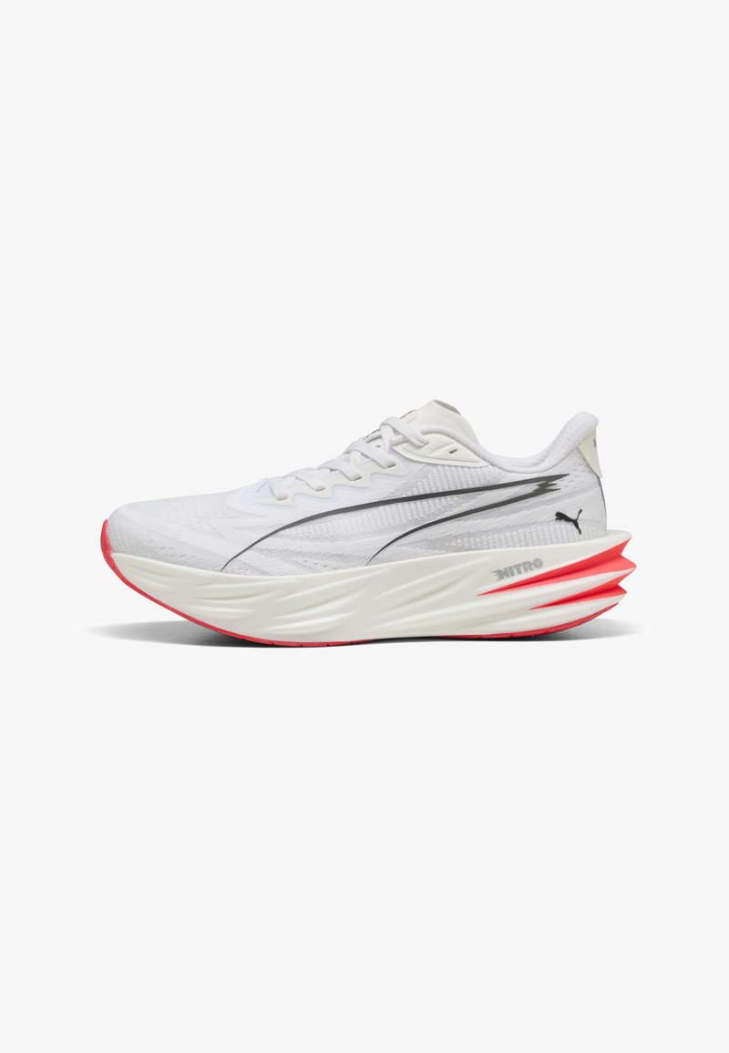 Chaussure de sport blanche avec une semelle épaisse sculptée, des accents rouges sur la semelle extérieure et un logo Puma noir sur la tige en mesh et la zone du talon.