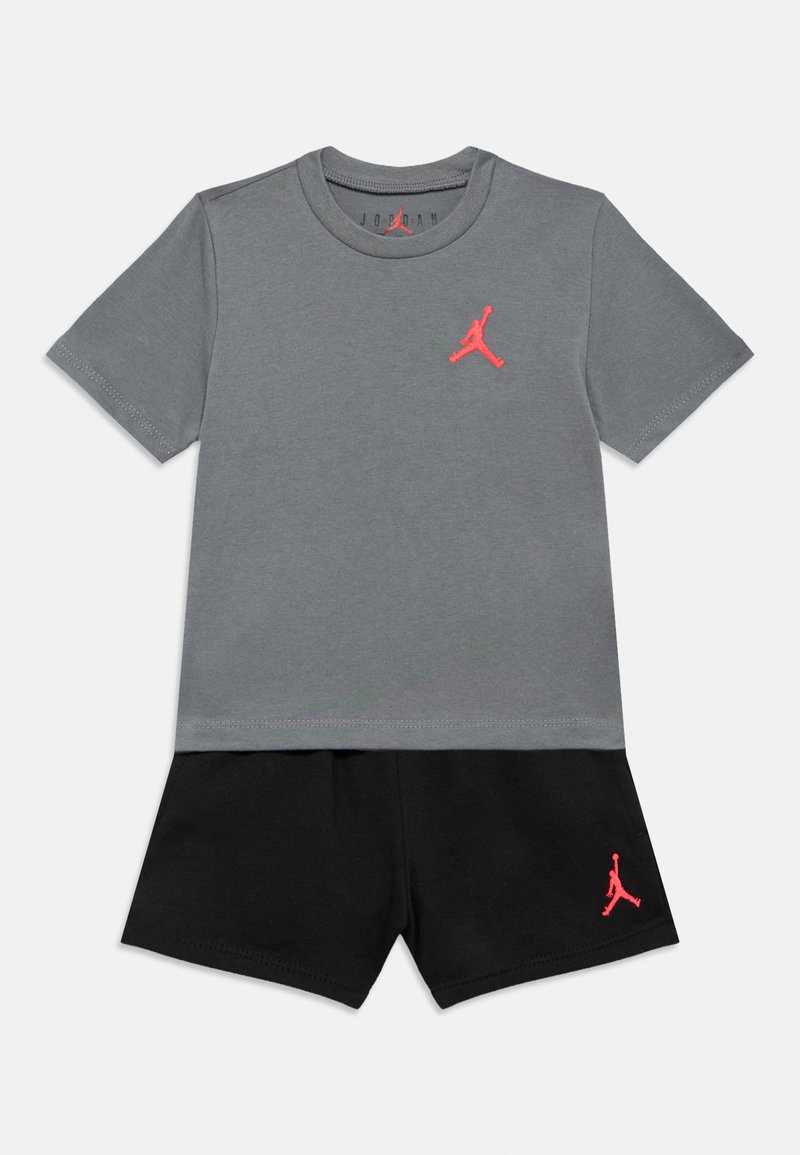 Γκρι κοντομάνικο T-shirt με ροζ λογότυπο Jordan στο στήθος, σε συνδυασμό με μαύρη σόρτς που φέρει το ίδιο ροζ λογότυπο. Υλικό βαμβάκι.