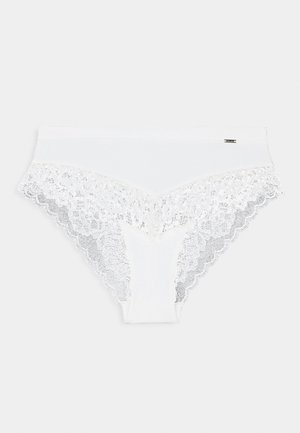 Valge puuvillane aluspüks, millel on pitsdetailid vöökoha ja jalgade avade ümber; omaduseks on lainelised servad ja sujuv viimistlus.