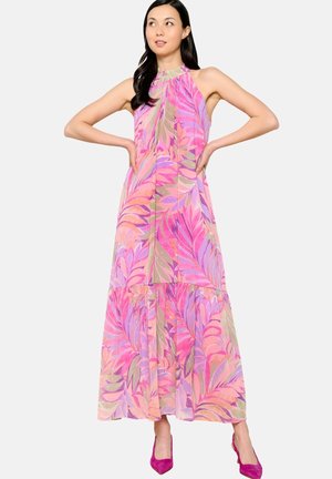 Abito lungo con un motivo floreale a foglie nei colori rosa, viola e verde. Design con collo halter, gonna a strati, abbinato a tacchi fucsia.