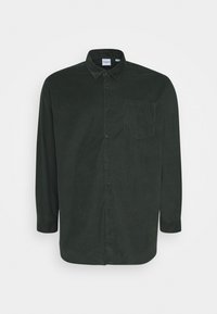 Camisa de pana verde oscuro con mangas largas, cierre de botones en la parte delantera y un único bolsillo en el pecho. Presenta un tejido texturizado y un diseño de cuello clásico.