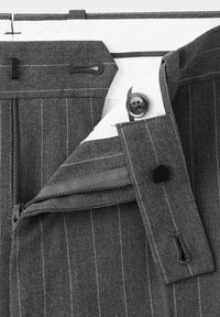 Ceinture de pantalon gris à fines rayures avec fermeture éclair, bouton, crochet et agrafe partiellement ouverte sur fond blanc.