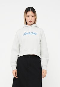 Felpa corta grigia chiara in cotone, con il logo blu "Santa Cruz". Maniche lunghe e design con cappuccio regolabile con cordino.
