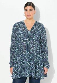 Blomstrede navy bluse med lange ærmer, V-hals og sammensyningsdetaljer. Med et flerfarvet print med strejf af grøn og blå. Let stof.