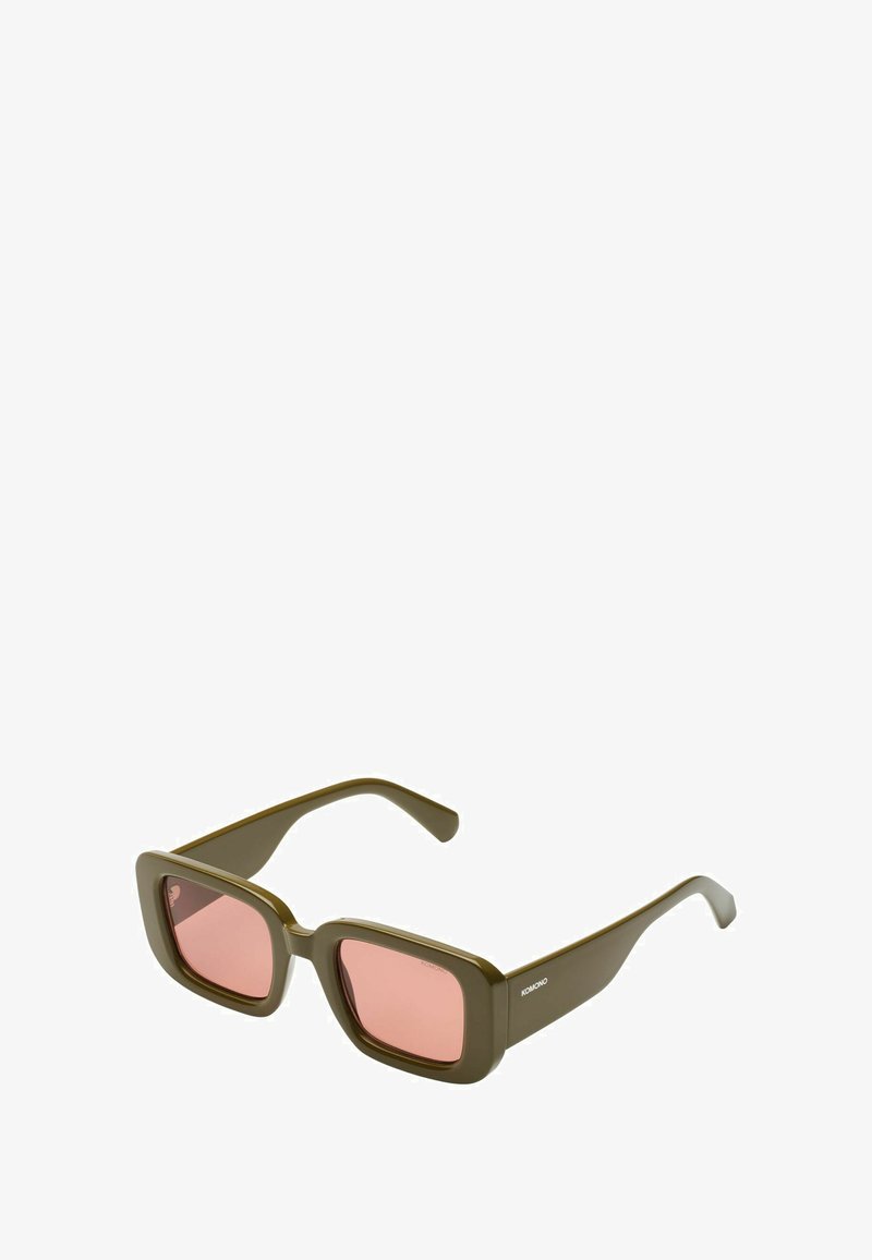 Lunettes de soleil carrées vert olive avec des verres roses. Monture épaisse au toucher lisse et branches larges. Logo sur le côté d'une branche.