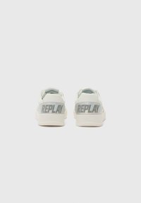 White sneakers with a smooth leather upper, featuring a reflective gray "REPLAY" logo on the heel, rounded toe, and textured sole.